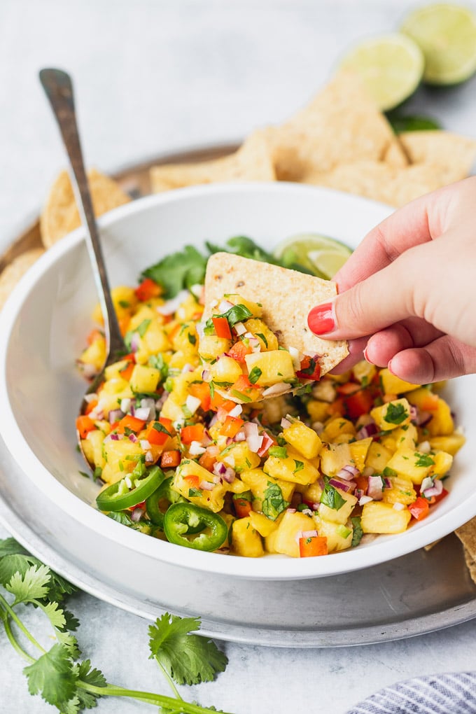 chip dipping into pineapple salsa