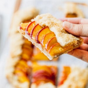 holding a slice of peach galette