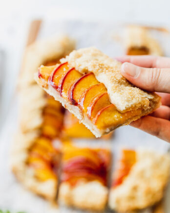 holding a slice of peach galette