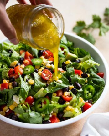 Pouring dressing on salad.