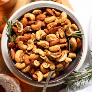 Bowl of sweet and spicy nuts with spoon.