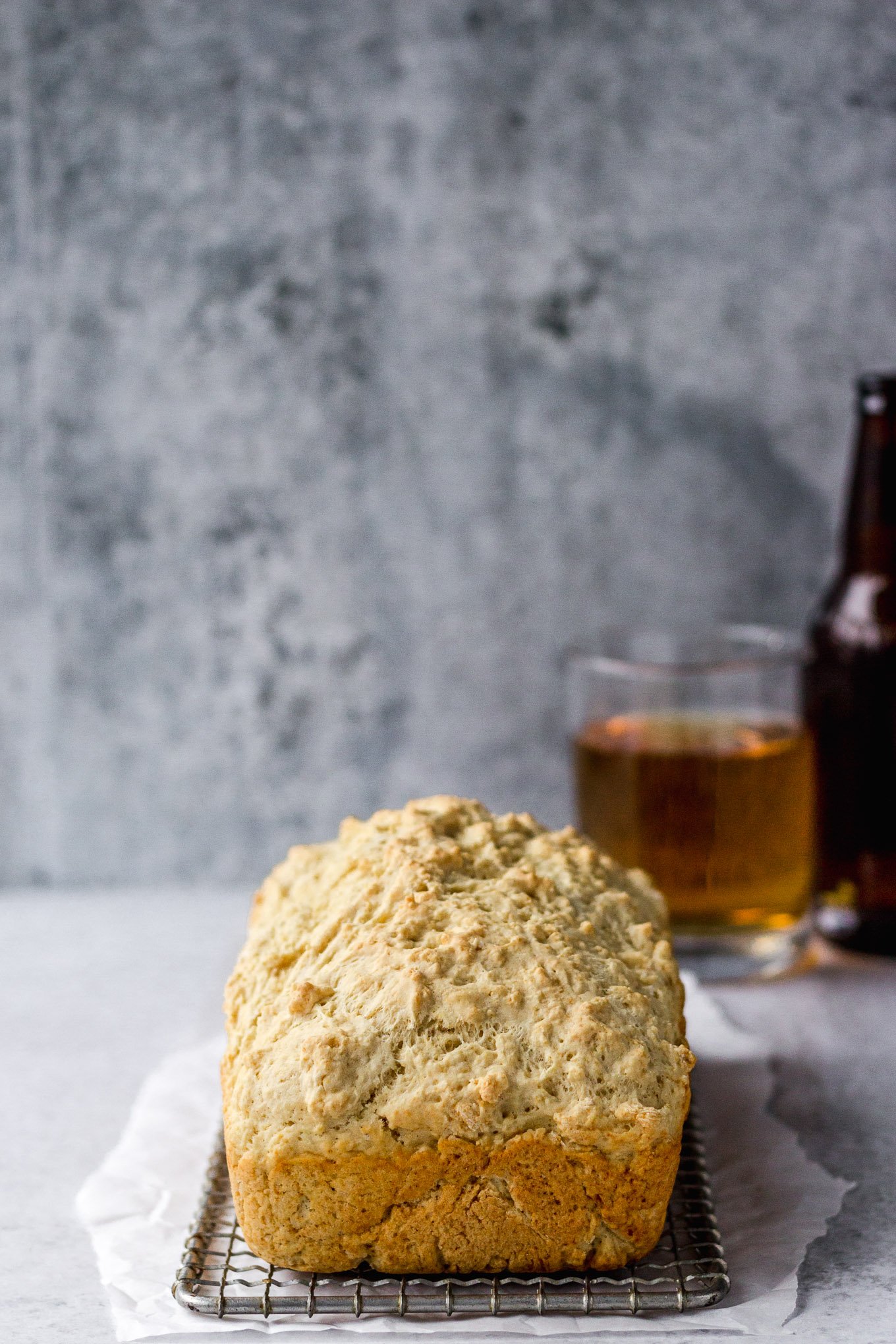 beer bread loaf on cooling rack and parchment paper