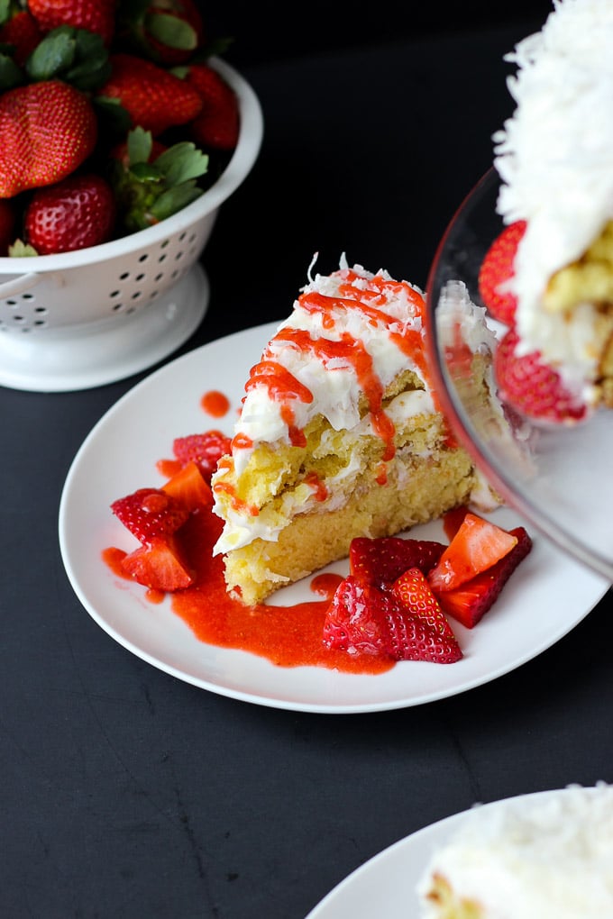 Strawberry Coconut Cake - moist, heavenly cake with a creamy coconut frosting, topped with fresh strawberries and a strawberry sauce! Perfect for any occasion!