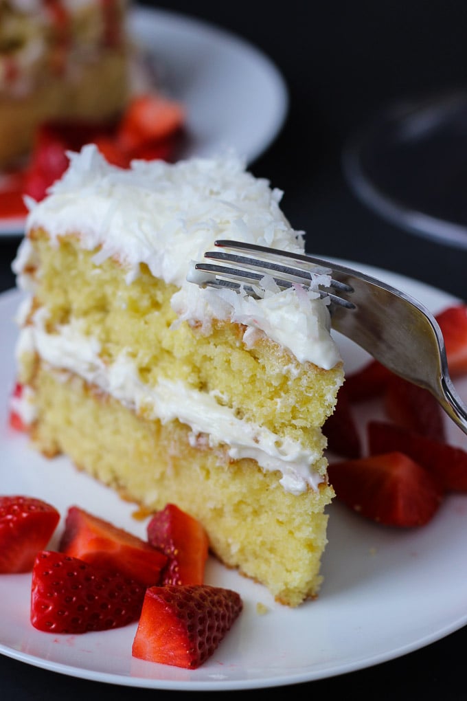 Strawberry Coconut Cake - moist, heavenly cake with a creamy coconut frosting, topped with fresh strawberries and a strawberry sauce! 