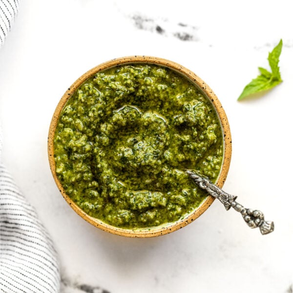 Small bowl with basil mint pesto and spoon.