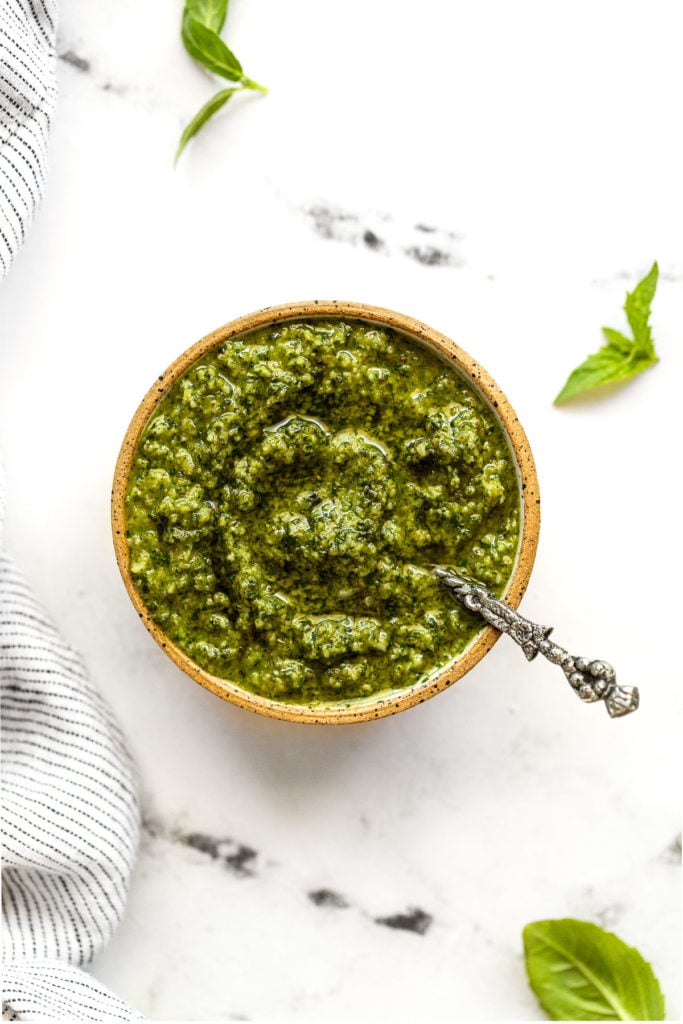 Small bowl with basil mint pesto and spoon.