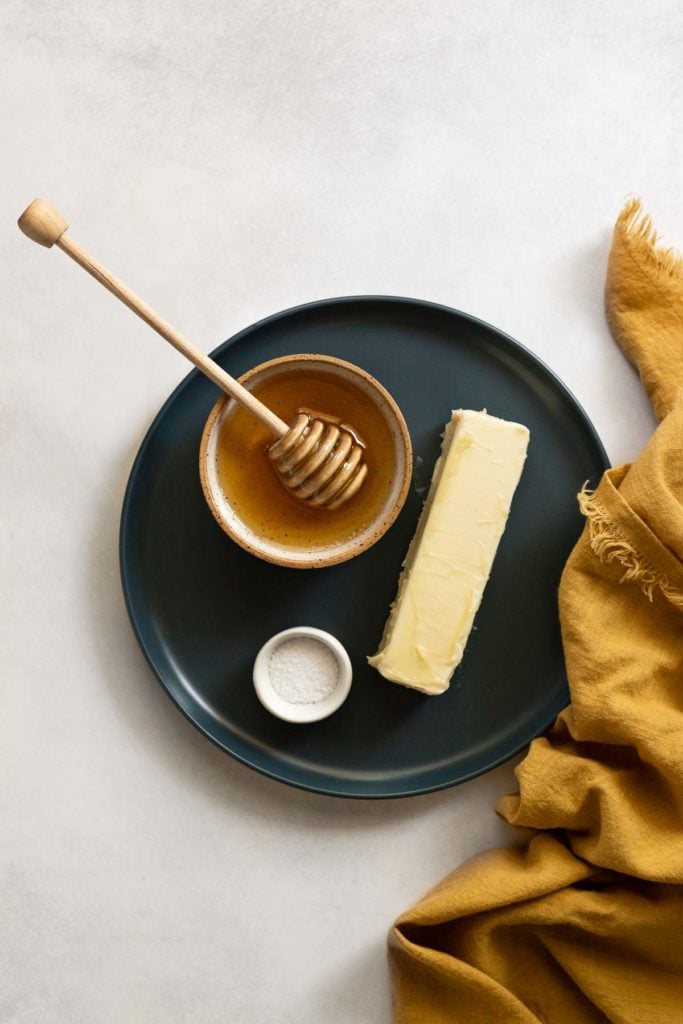 Plate with stick of butter, honey, and salt.