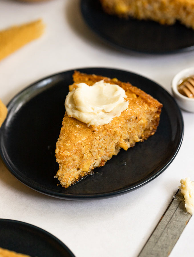 Cornbread slice with honey butter on top.