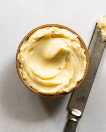 Bowl of whipped honey butter next to knife.
