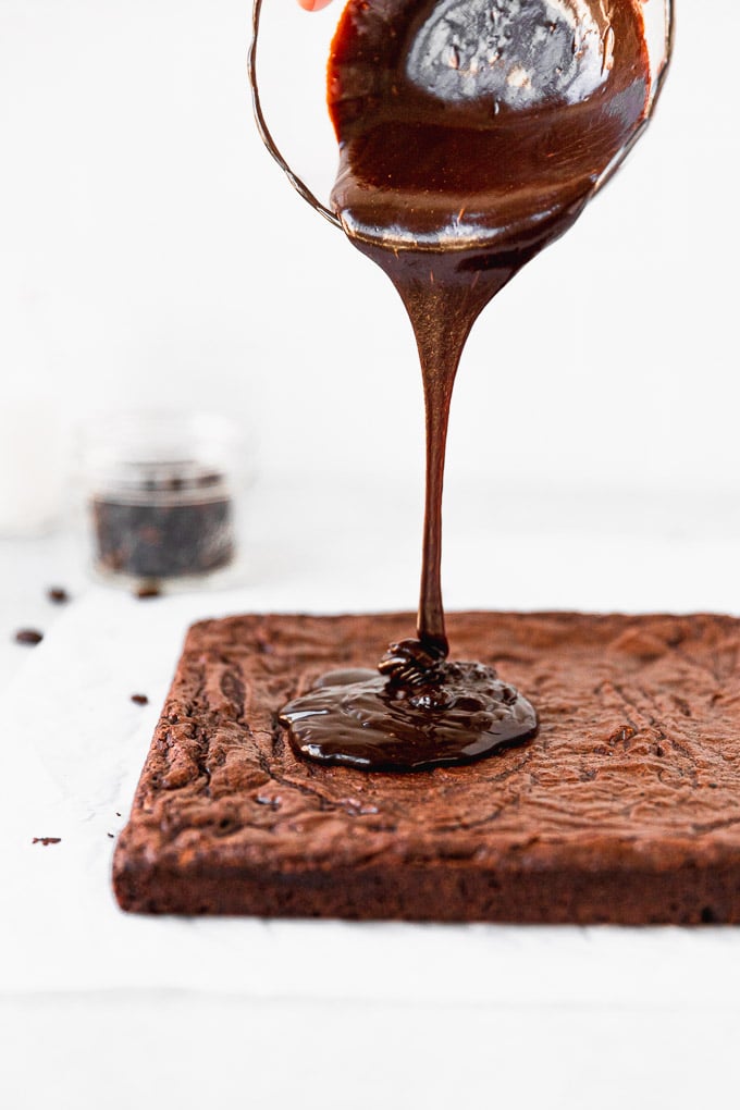 pouring espresso ganache on brownies