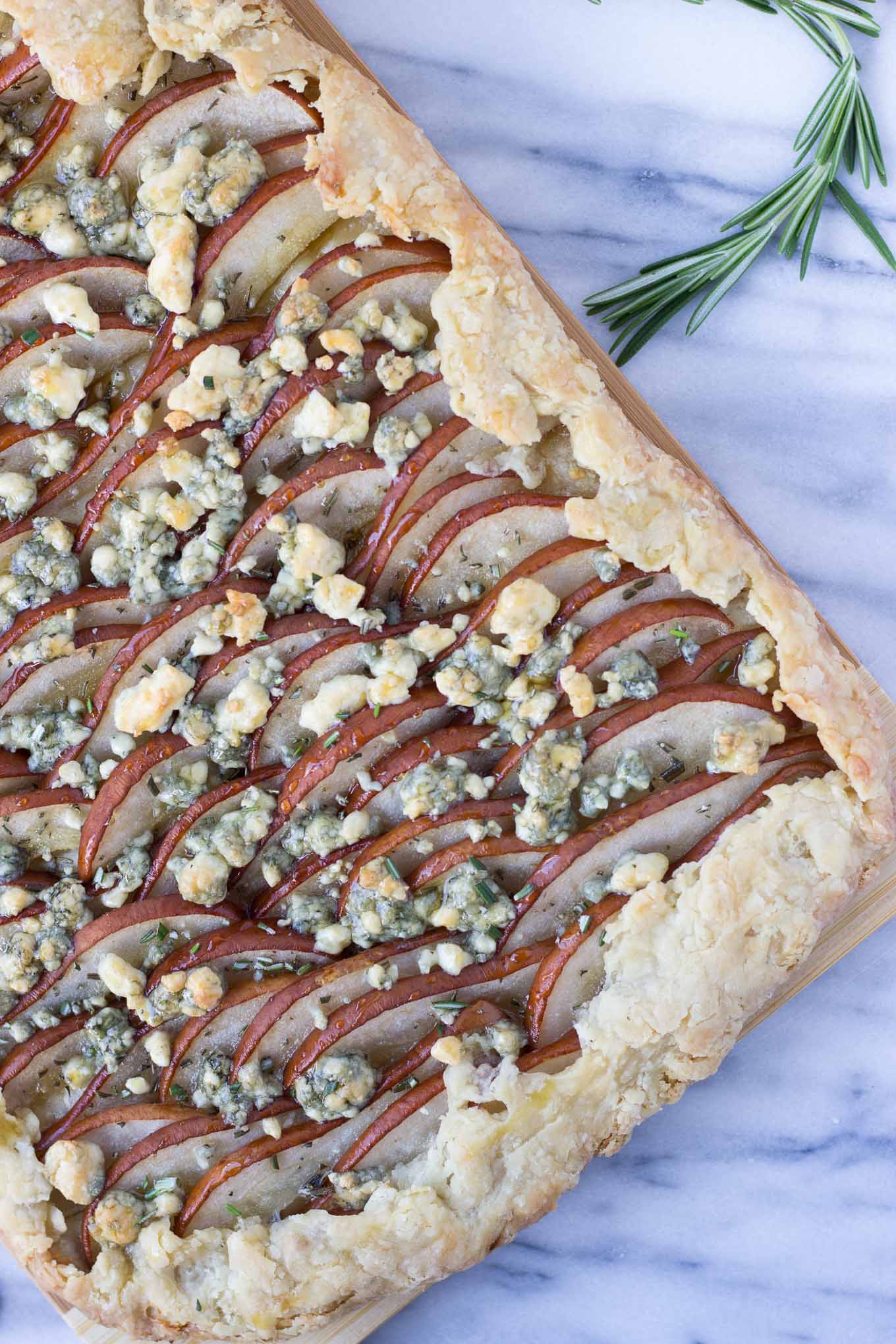 Savory Pear Tart - a flakey crust topped with Bosc pears, rosemary, gorgonzola, and drizzled with honey for the delicate balance of sweet and savory! 
