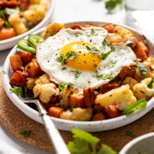 Two plates of sweet potato has with fried egg on top.