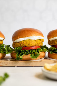 Three chickpea burgers in a row on a tray.