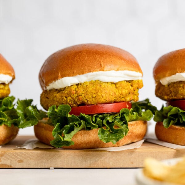 Three chickpea burgers in a row on a tray.