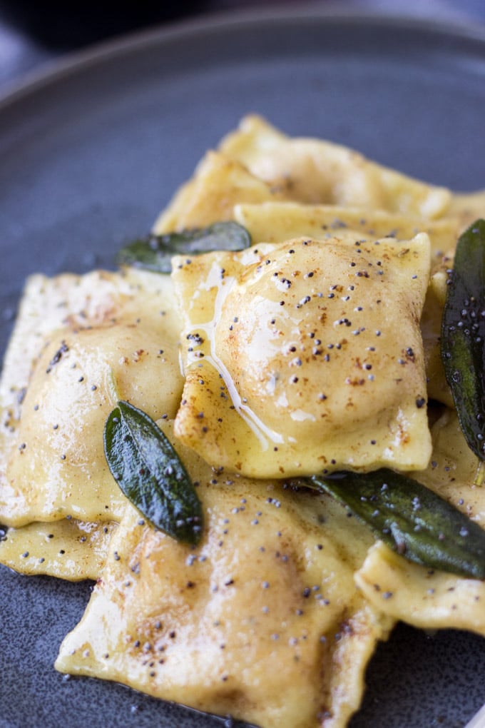 Up close brown butter poppy seed sauce on ravioli.