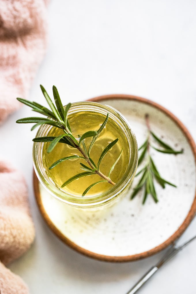 Jar of syrup with rosemary sprig.