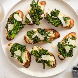 White bean crostini with broccoli on plate.