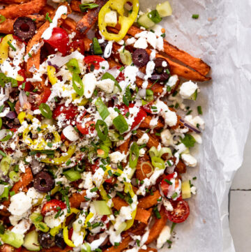 Sheet pan of loaded fries with toppings.