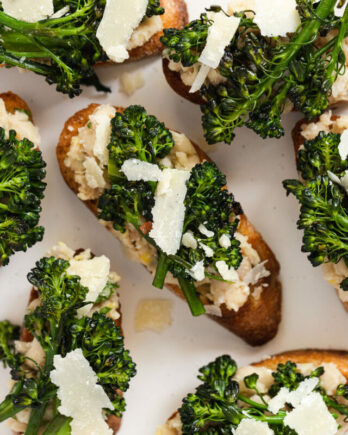 Broccolini and white bean crostini on plate up close.