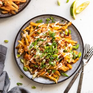 Plate of kimchi fries next to forks.