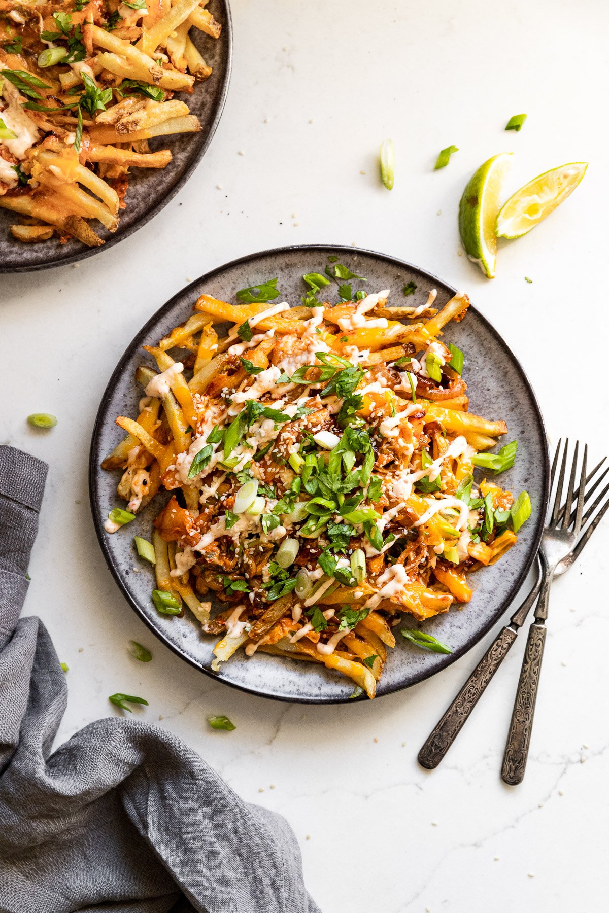 Plate of kimchi fries next to forks.