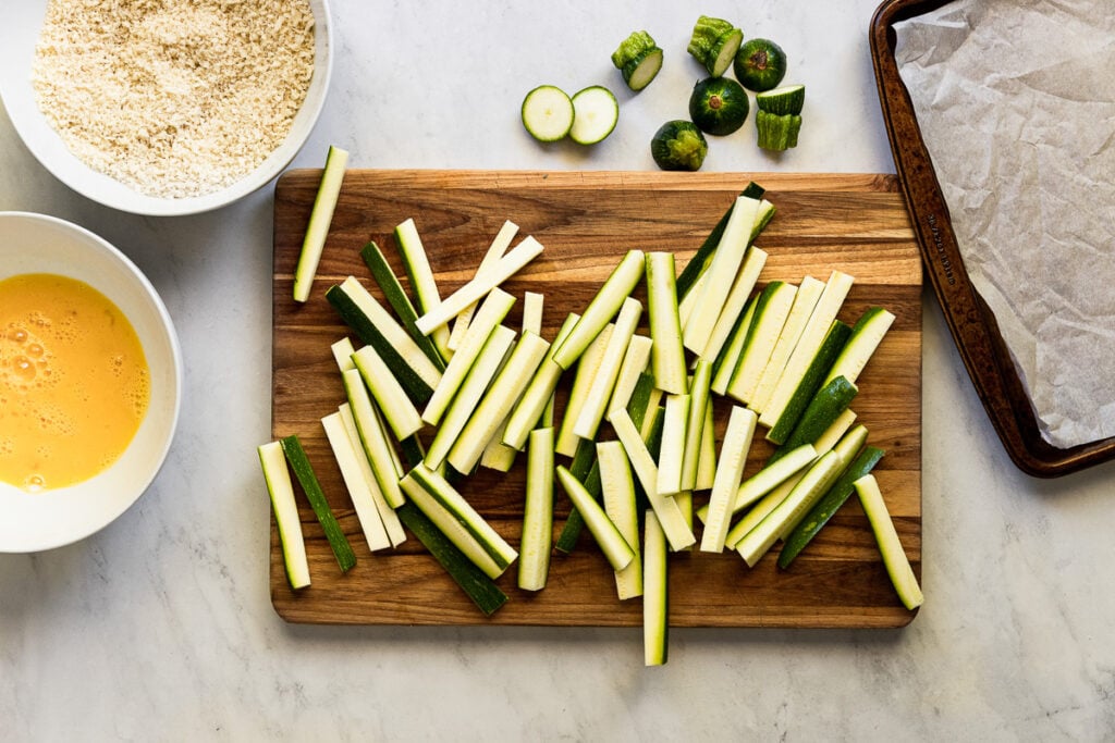 Zucchini sticks on cutting board.