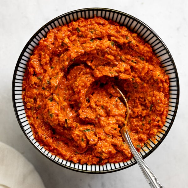 Bowl of romesco sauce with spoon.