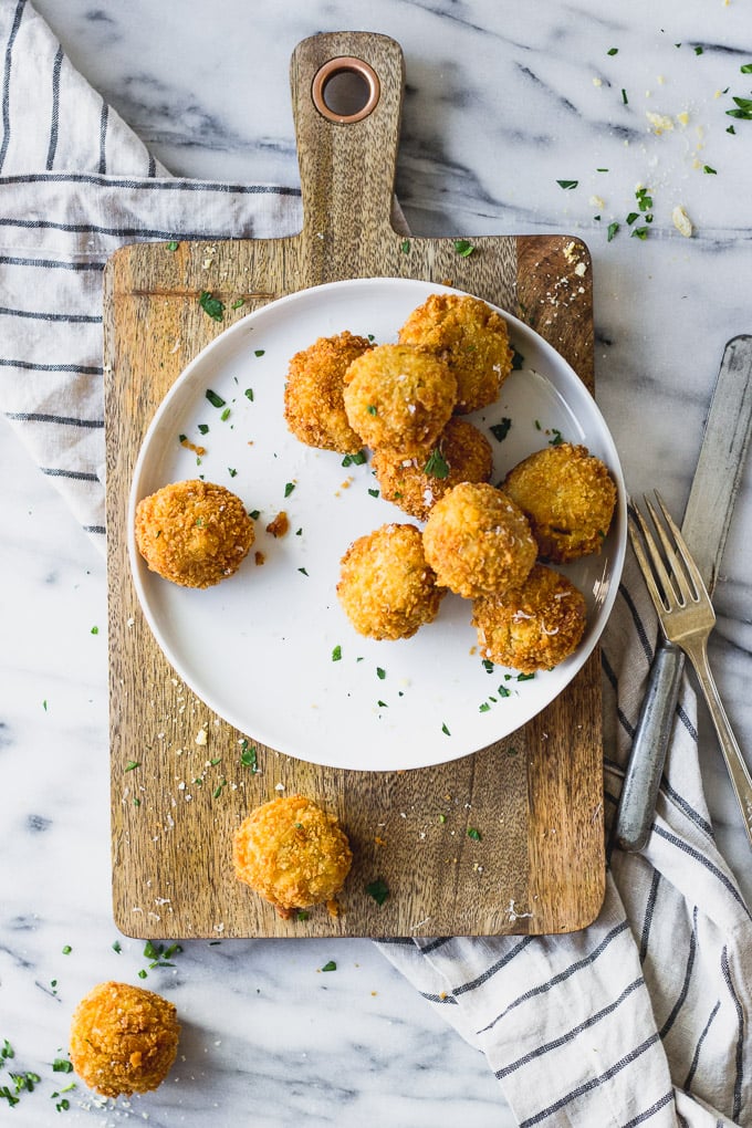Scalloped Corn Arancini on plate and serving platter
