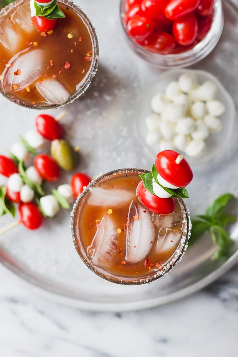 overhead bloody mary with tomatos, mozzarella, and basil on tray