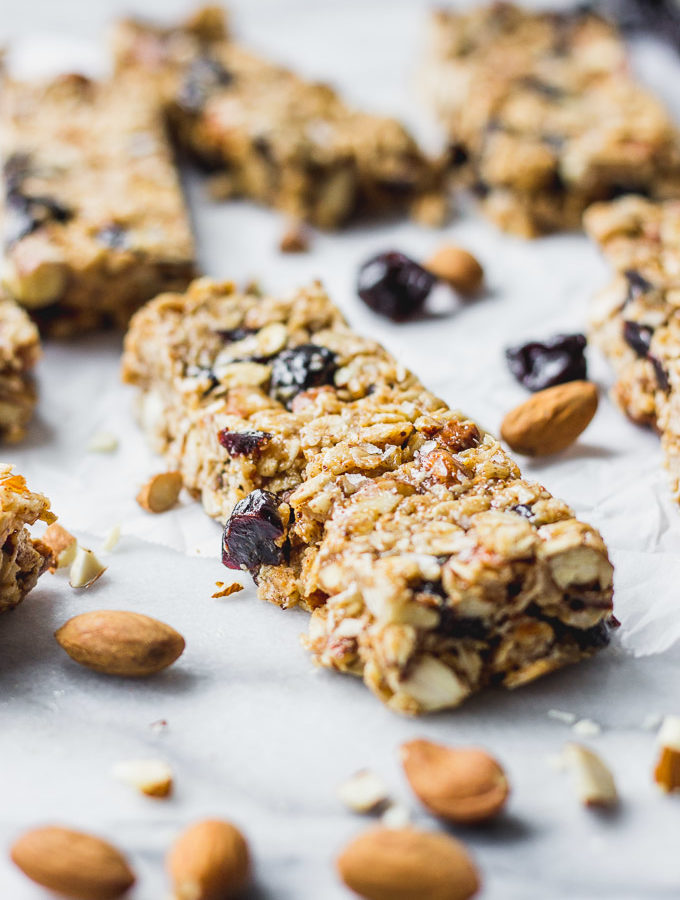 cherry almond granola bars spread out on white background