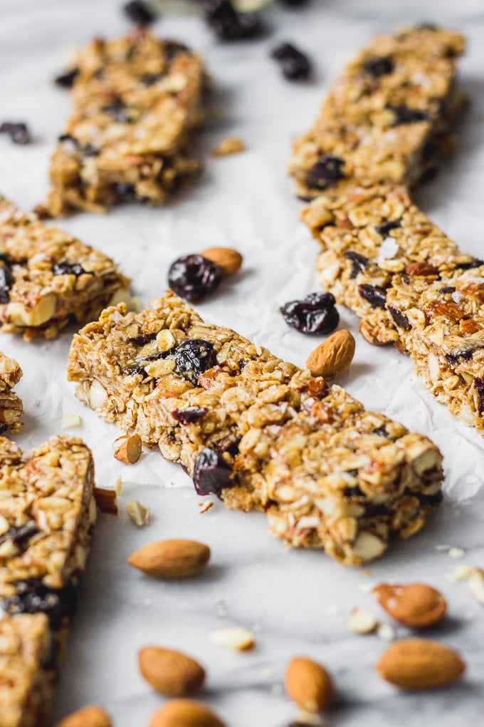 cherry almond granola bars spread out on white background