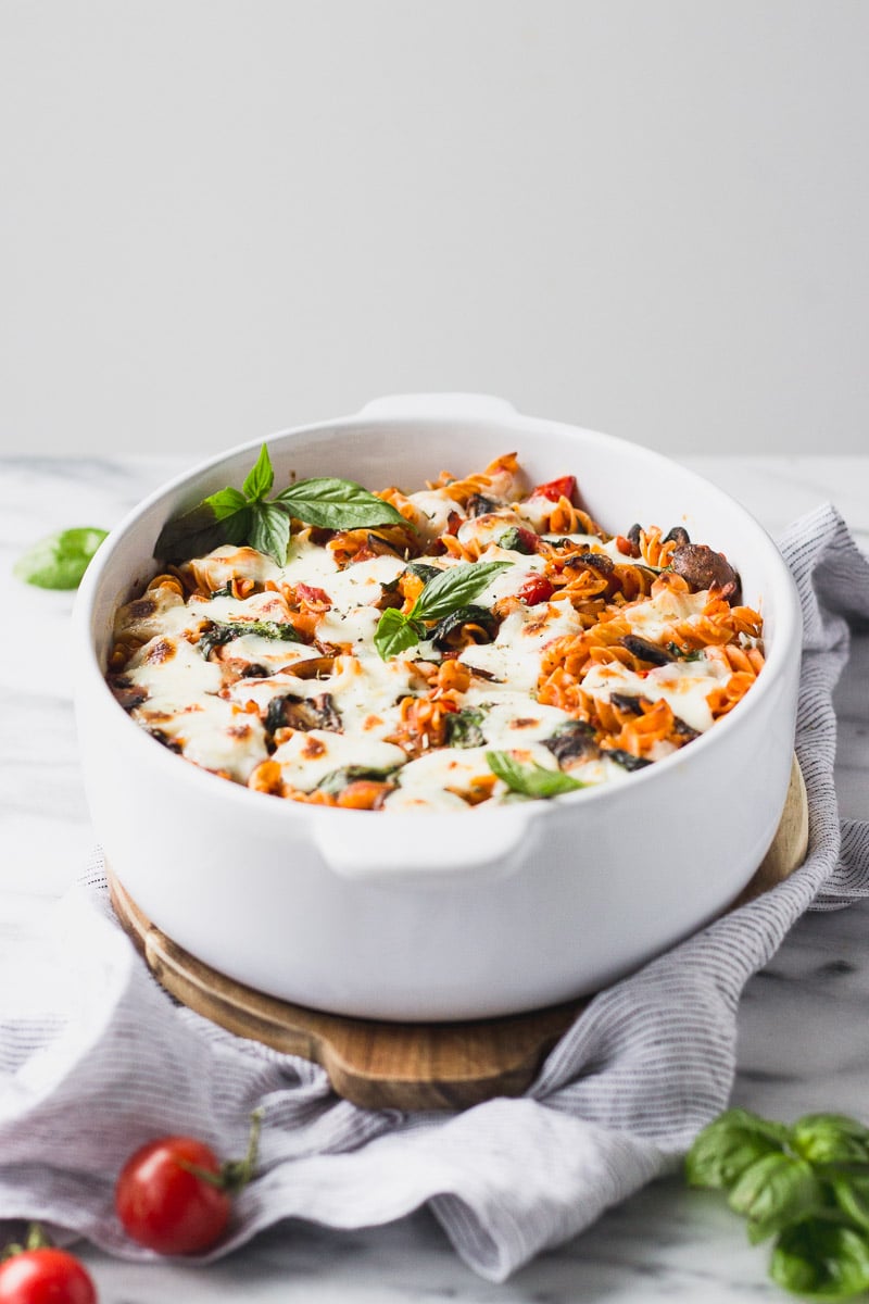vegetable baked pasta with basil in white casserole dish