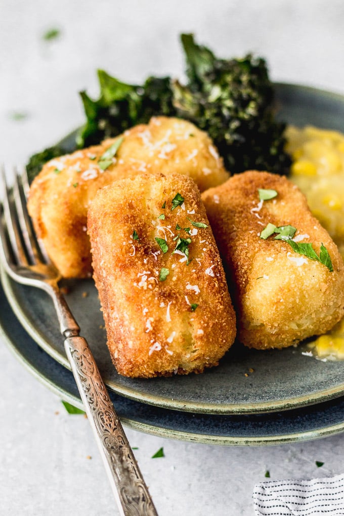 potato croquettes on plate with kale and creamed corn