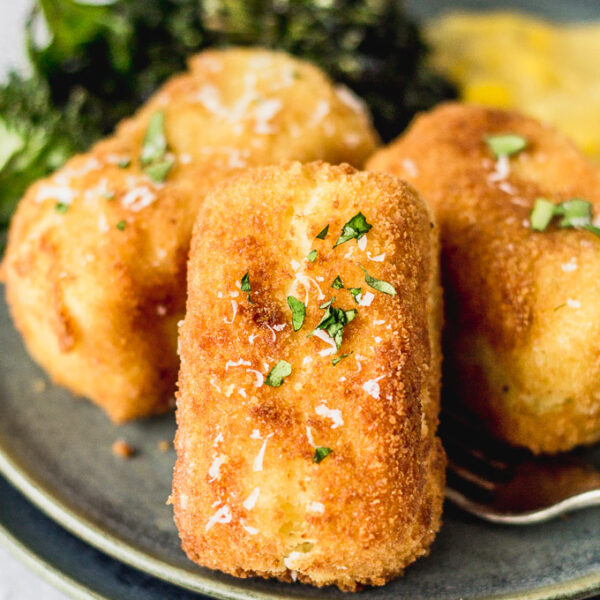 potato croquettes on plate with kale and creamed corn