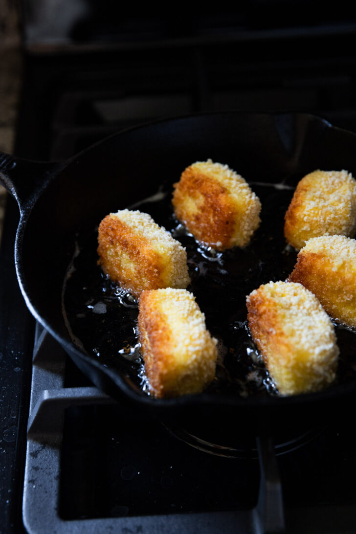 Croquettes in skillet frying.