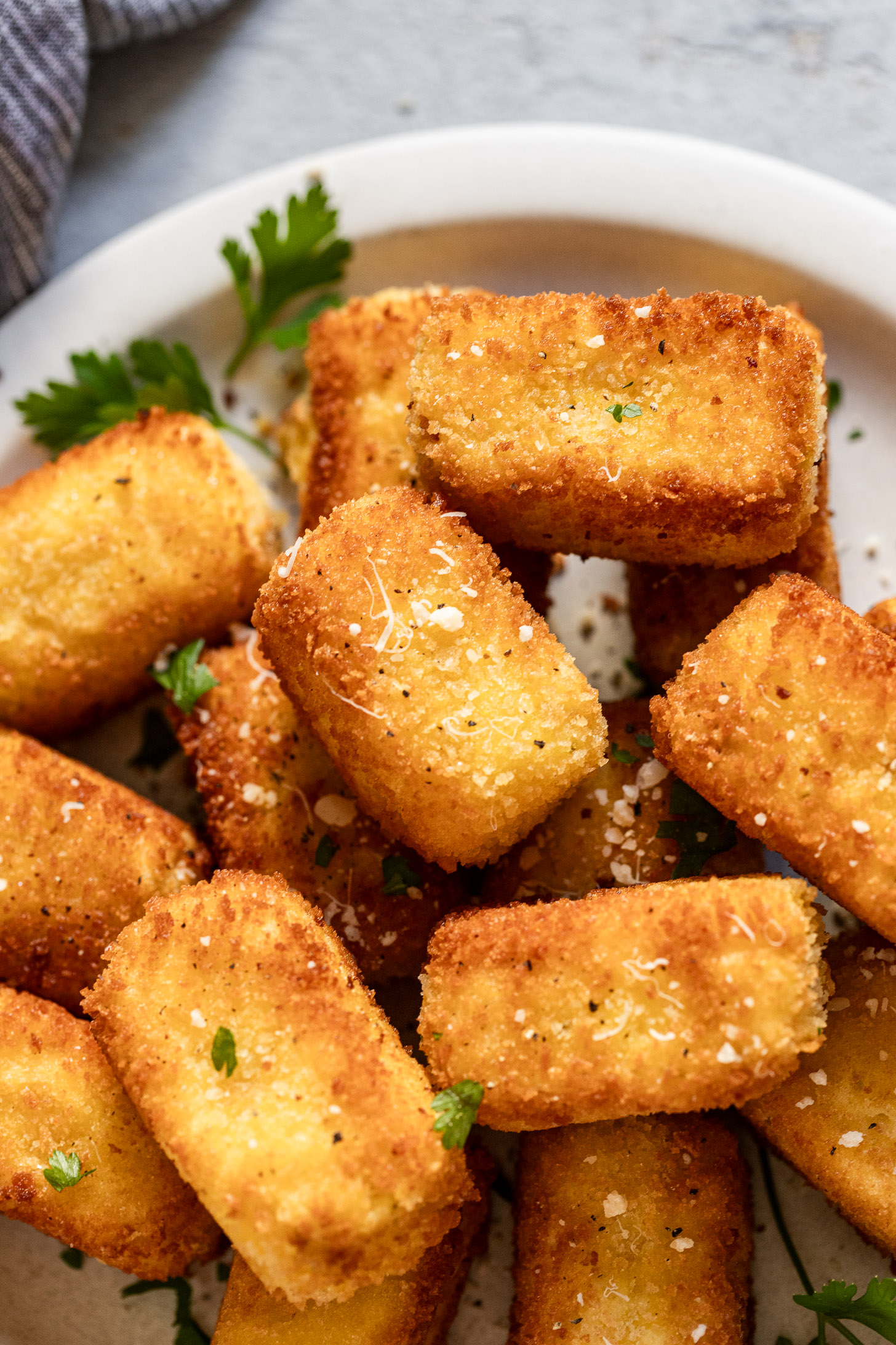 Plate of potato croquettes with parmesan cheese and parsley.