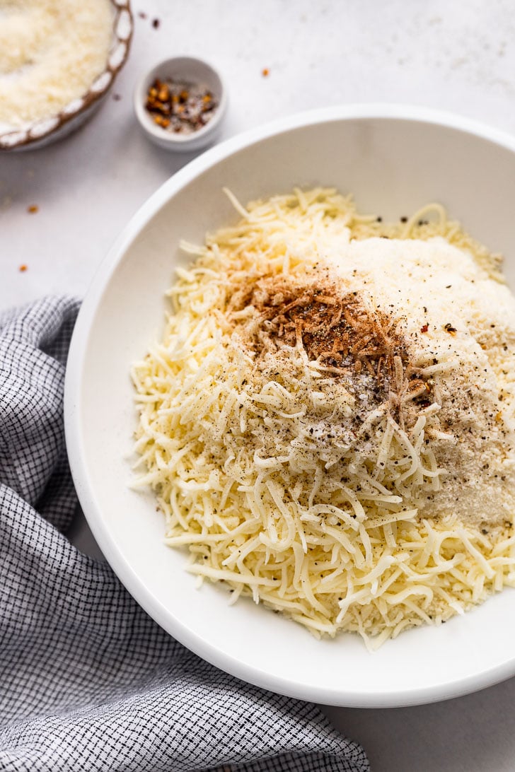 Shredded cheese in bowl with spices.