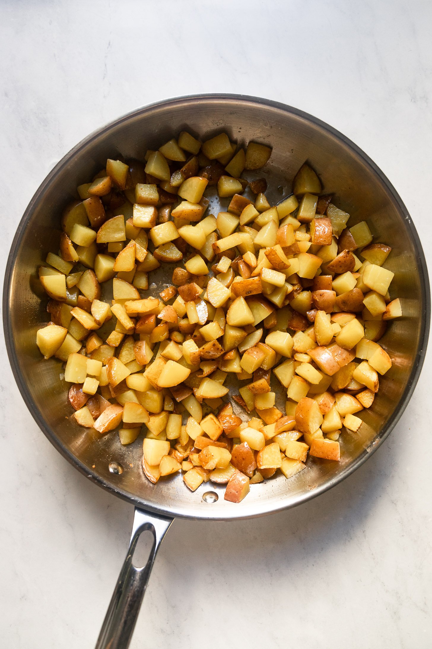 Diced potatoes in skillet.