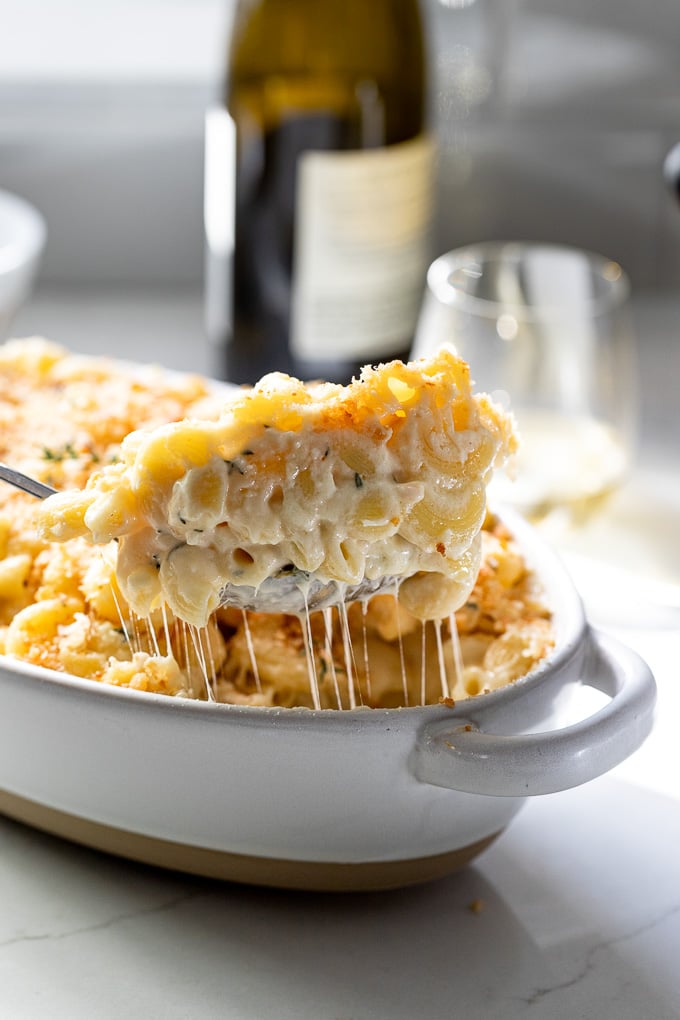 Scoop of white wine mac and cheese out of dish.