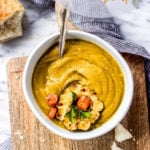 Curried Carrot Squash Soup in a white bowl with spoon by Fork in the Kitchen