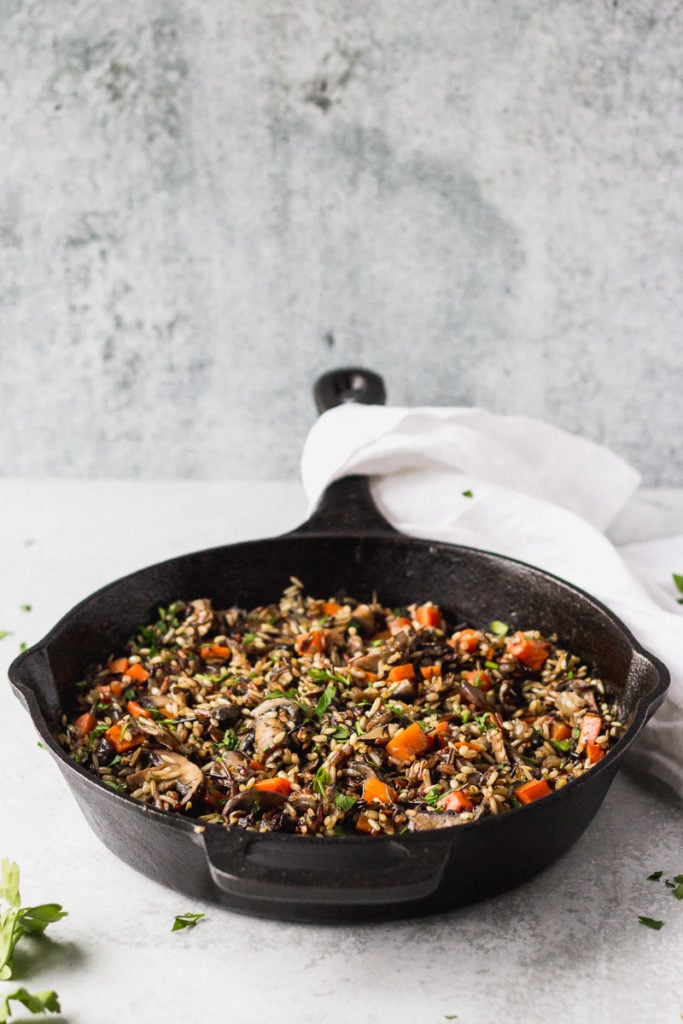 Herbed Wild Rice with Mushrooms in cast iron skillet by fork in the kitchen