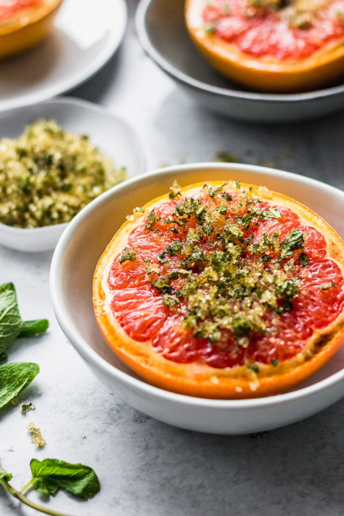 broiled grapefruit with mint and sugar by fork in the kitchen
