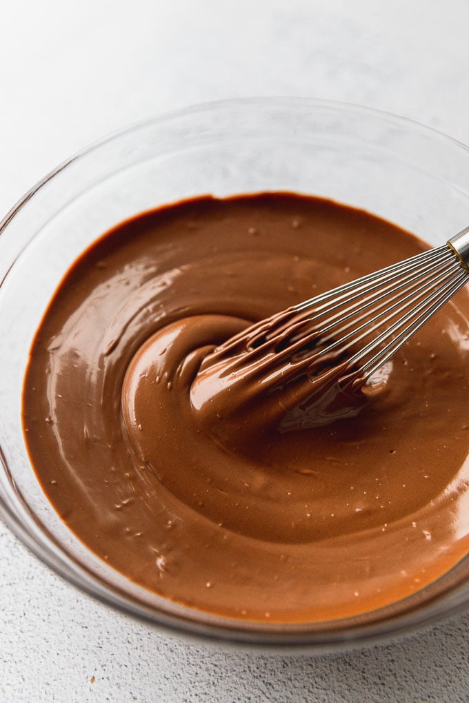 Bowl of melted chocolate with whisk.