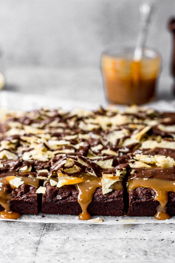 brownies with salted caramel, potato chips, and a chocolate drizzle by fork in the kitchen