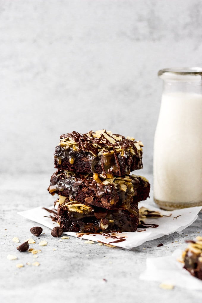 stack of brownies with caramel, potato chips, and chocolate drizzle by fork in the kitchen