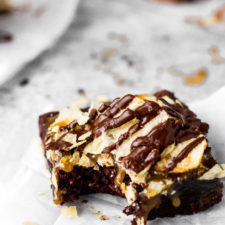 brownies with salted caramel with potato chips and chocolate drizzle with bite by fork in the kitchen