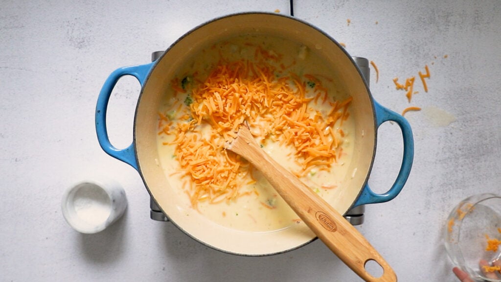 Shredded cheese into soup.