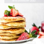 lemon mascarpone pancakes with strawberry sauce stacked on plate by fork in the kitchen