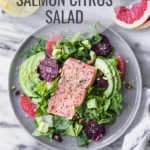 salmon citrus salad with avocado on plate by fork in the kitchen