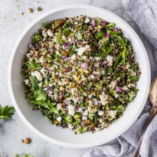 quinoa salad in white bowl with spoon by fork in the kitchen